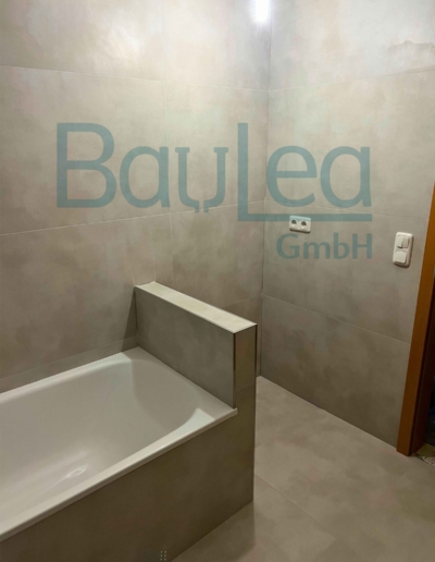 Badsanierung München NACHHER – Badewanne mit gefliestem Verkleidungspanel, Betonoptik-Fliesen