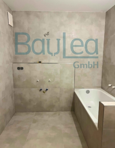 Badsanierung München – großformatige Betonoptik-Fliesen, Badewanne mit gefliestem Podest